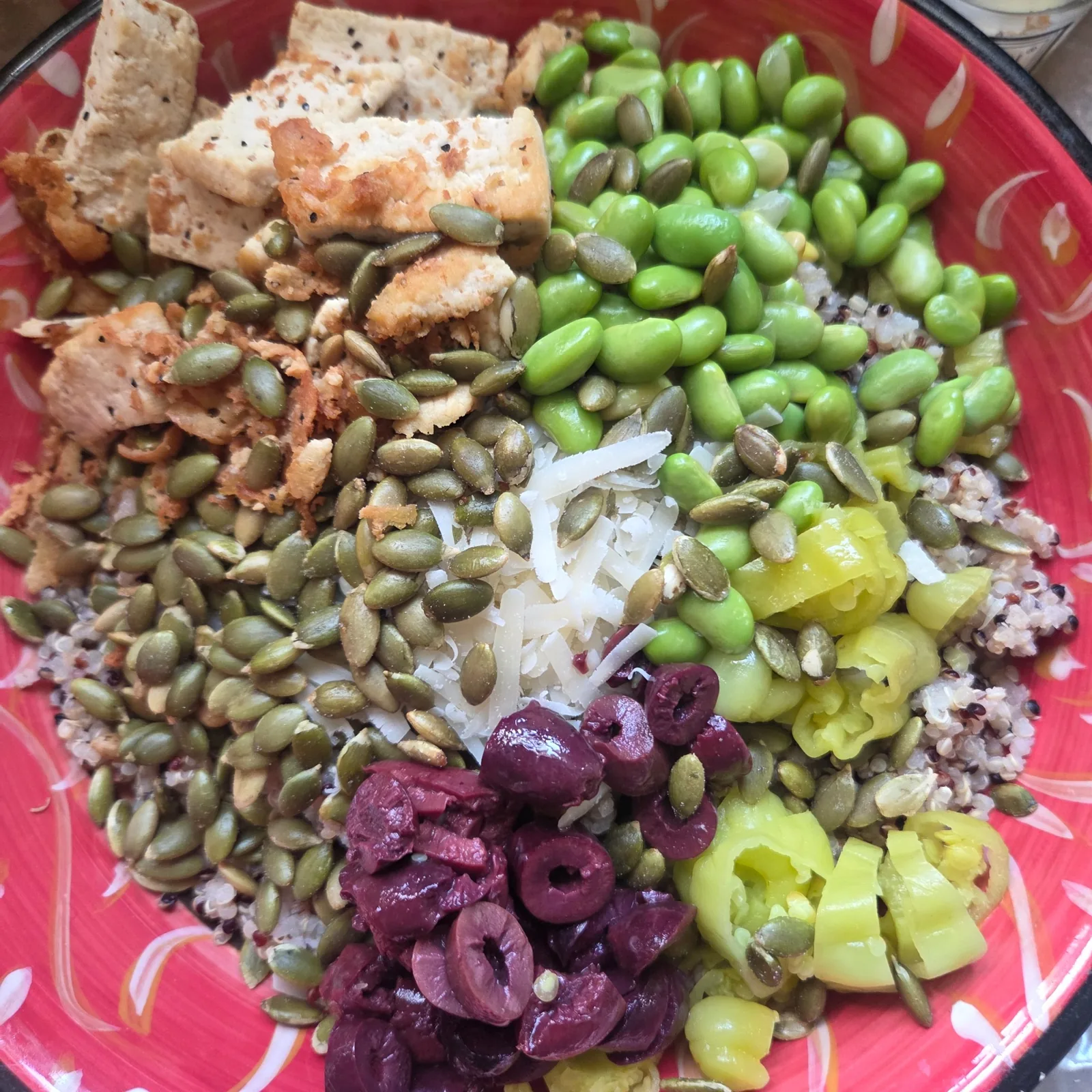 A grain bowl with edamame, roasted vegetables, and pumpkin seeds