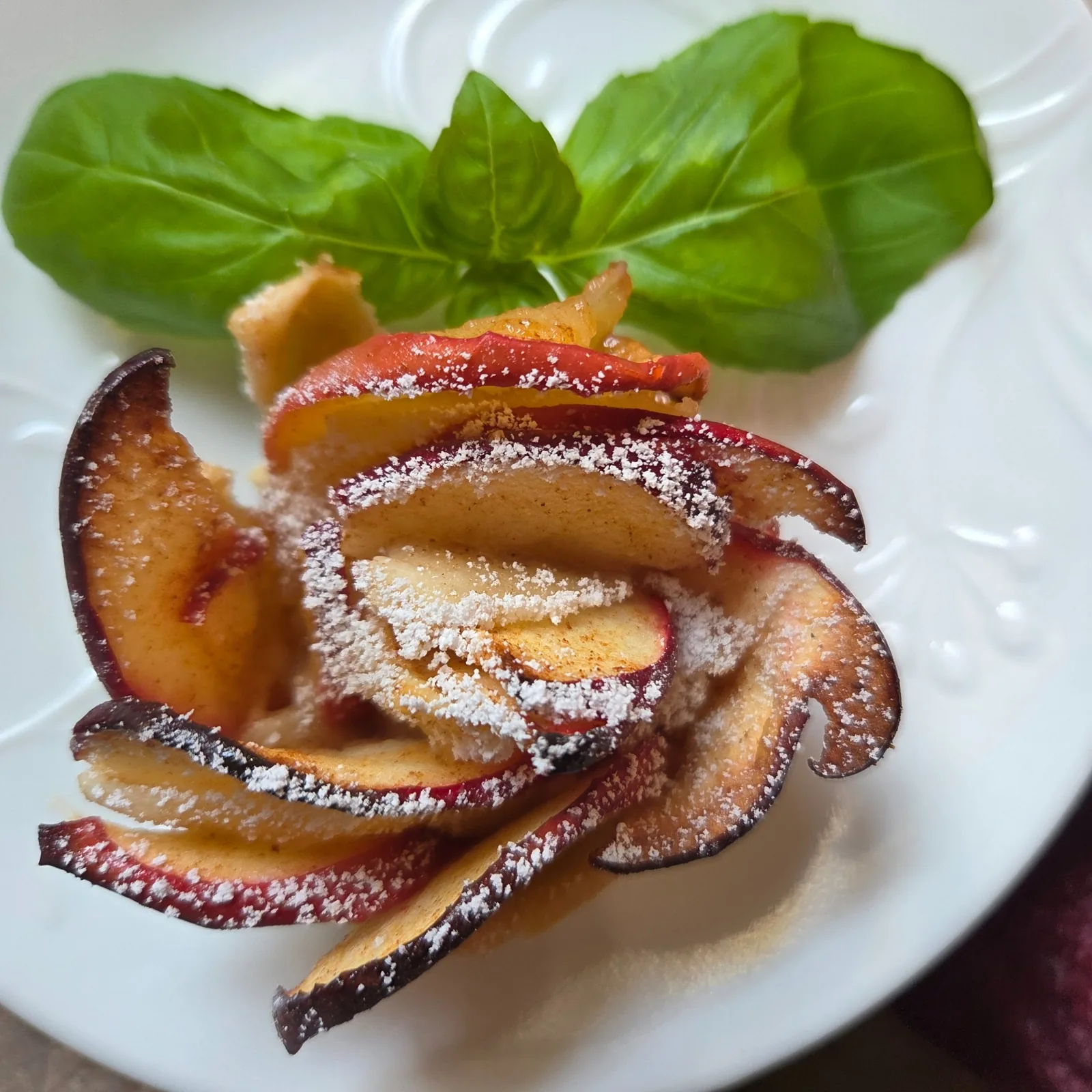 A plated fruit dessert dusted with powdered sugar